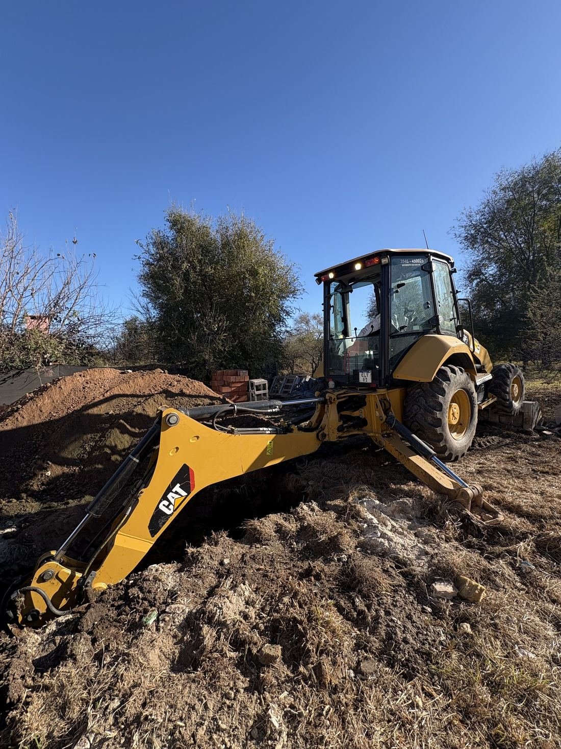 Retroexcavadora moviendo tierra en un terreno