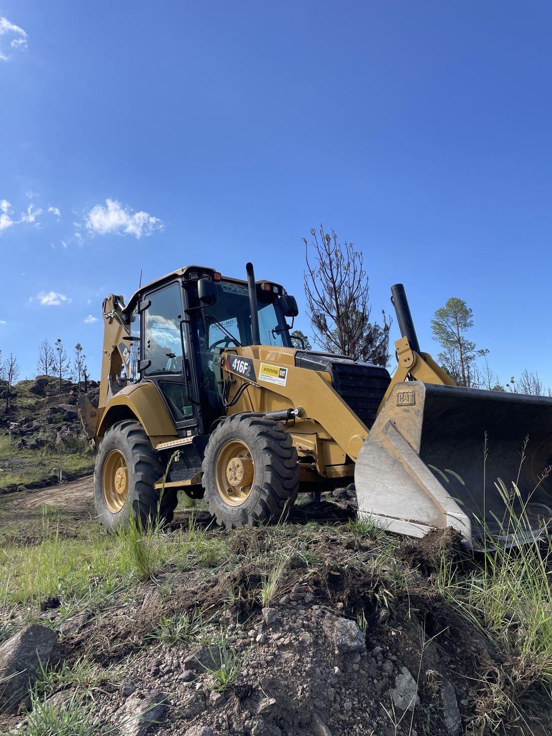 Retroexcavadora Caterpillar 416F2 de CONSER trabajando sobre una pendiente